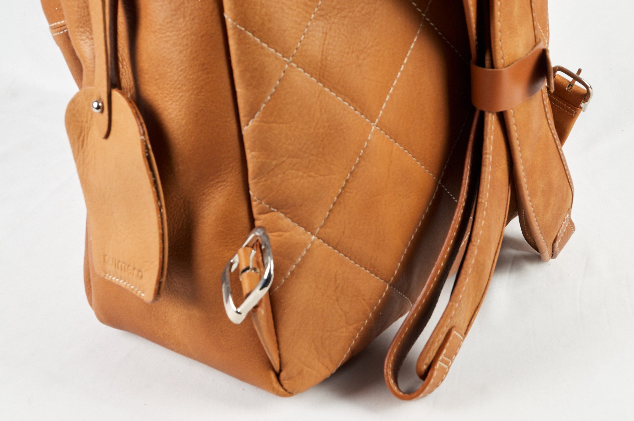 Morral de cuero cognac ROCKY detalle, mostrando asas superiores y detalles de costura alcolchado.
