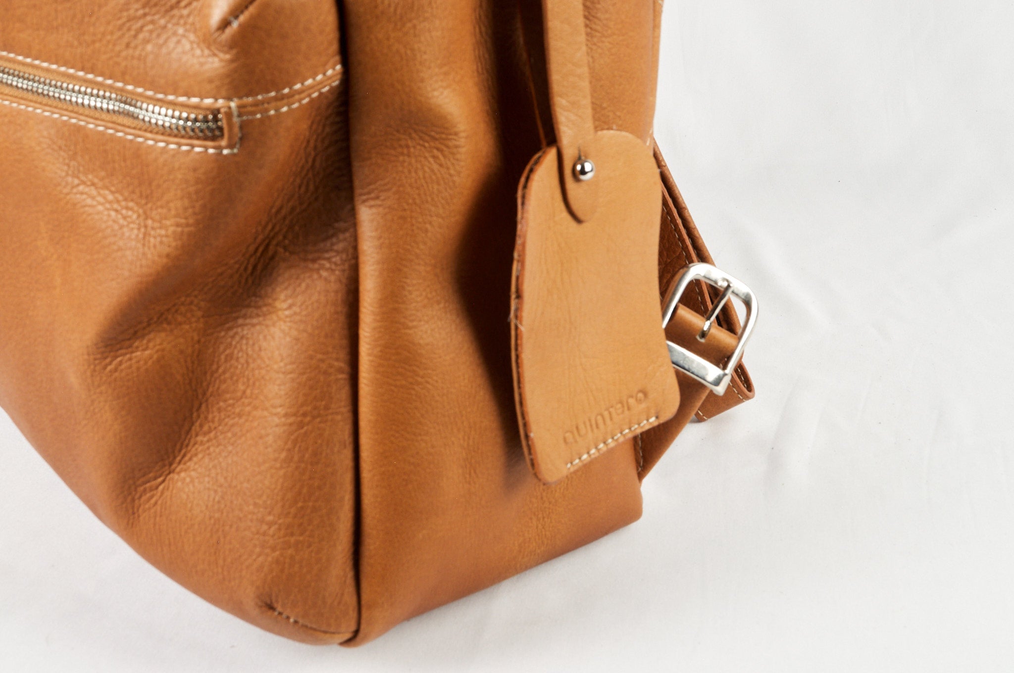 Detalle del morral de cuero cognac ROCKY acostado, mostrando su ID.