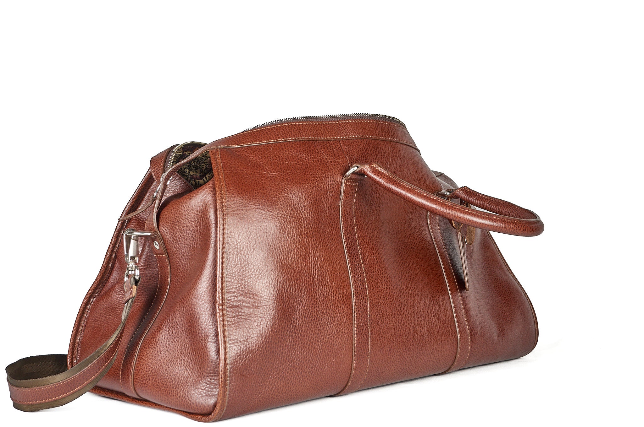 Bolso duffel Maverick en cuero natural, vista lateral mostrando asas cortas.