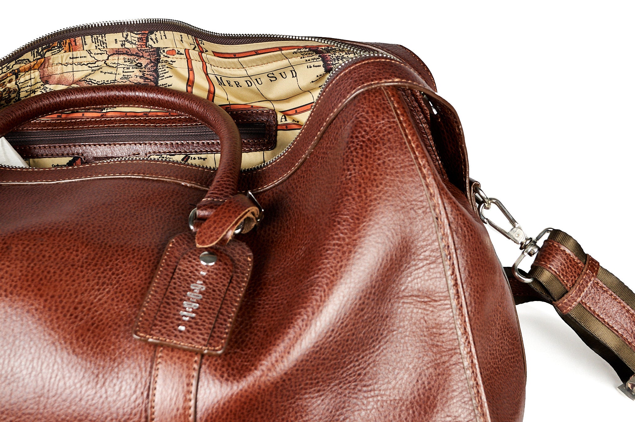 Bolso duffel Maverick en cuero cognac, detallel resaltando la textura del cuero.