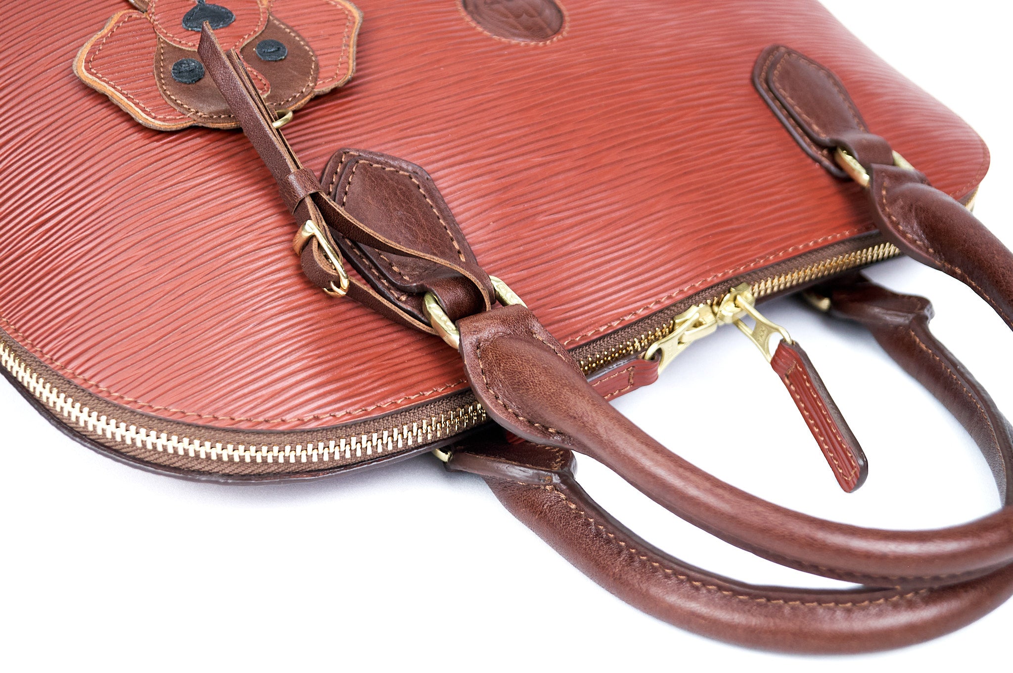 Primer plano del bolso de cuero cognac PERRITO, enfocándose en la textura del cuero y el acabado artesanal.