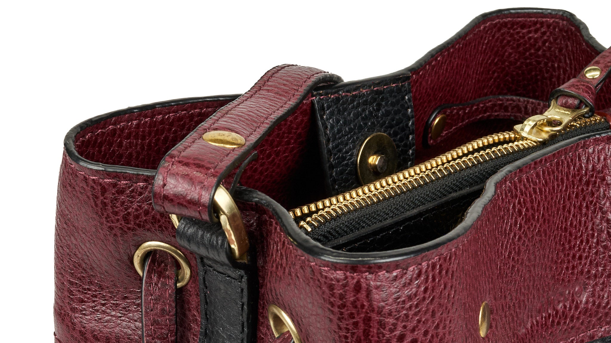 Detalle del interior del bolso bucket VALDÉZ, en cuero negro y vino tinto, con cierre de cremallera y compartimento interno.
